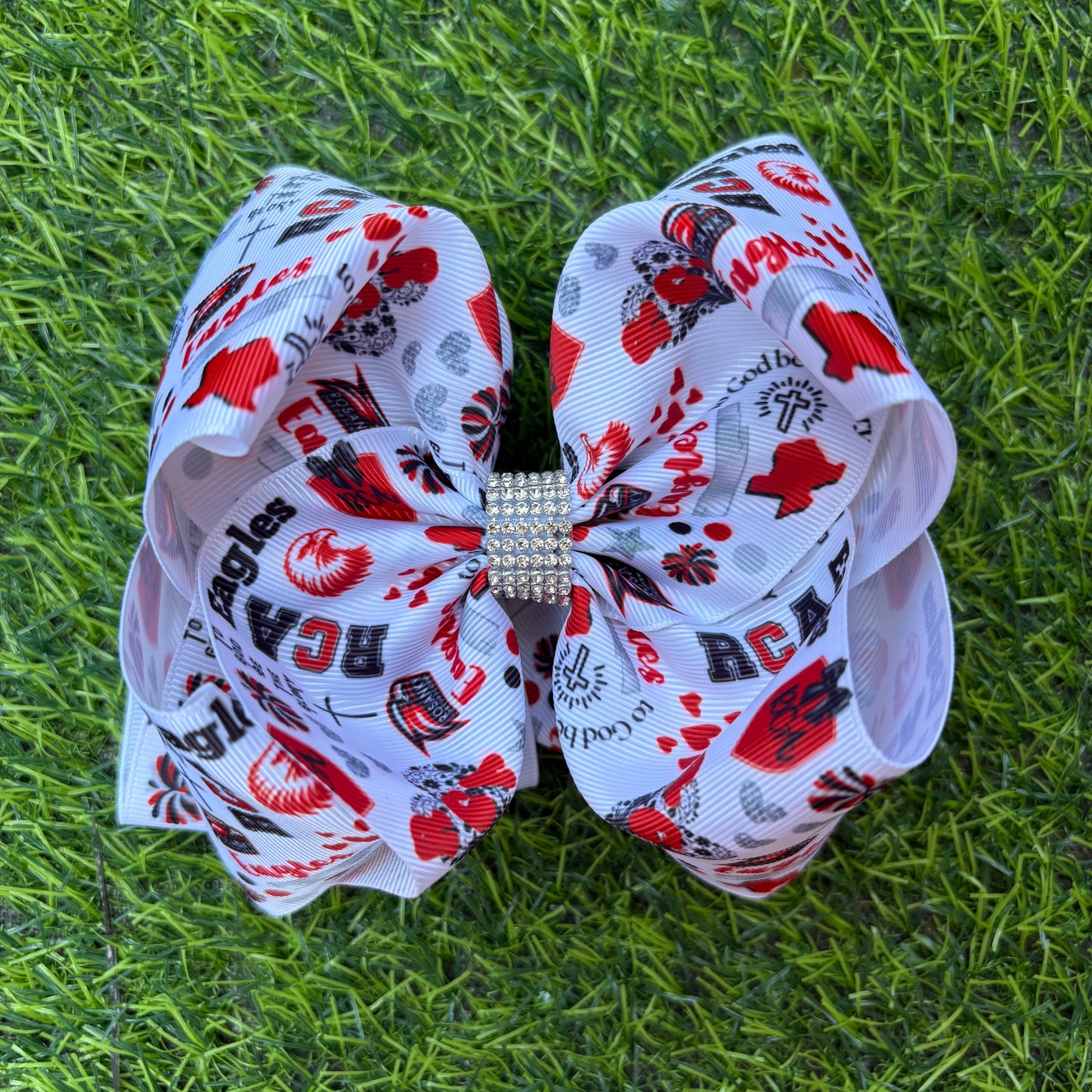 Large decorative bow with red and black patterns on a grass background