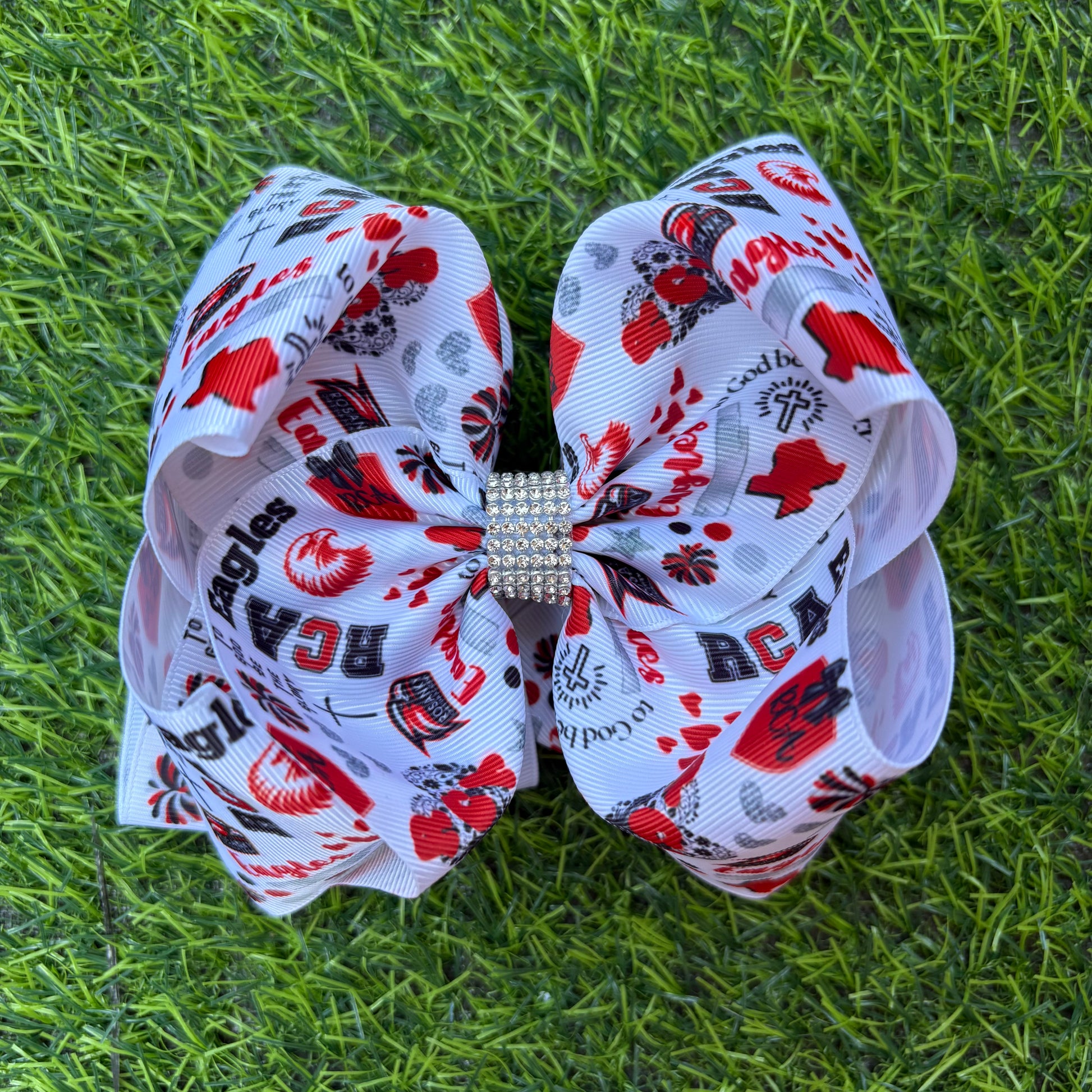 Large decorative bow with red and black patterns on a grass background