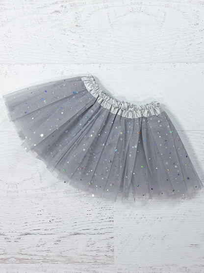 This soft grey tutu is made from polyester tulle, with a silver satin elastic waistband.  The top of three layers is covered with silver sparkle dots in varying sizes.  