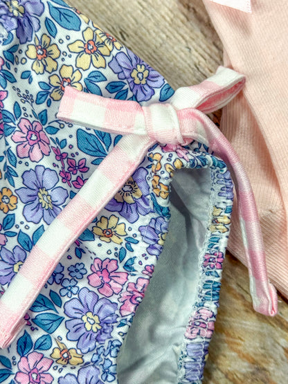 close up of gingham bow tie on side of floral bottoms of romper
