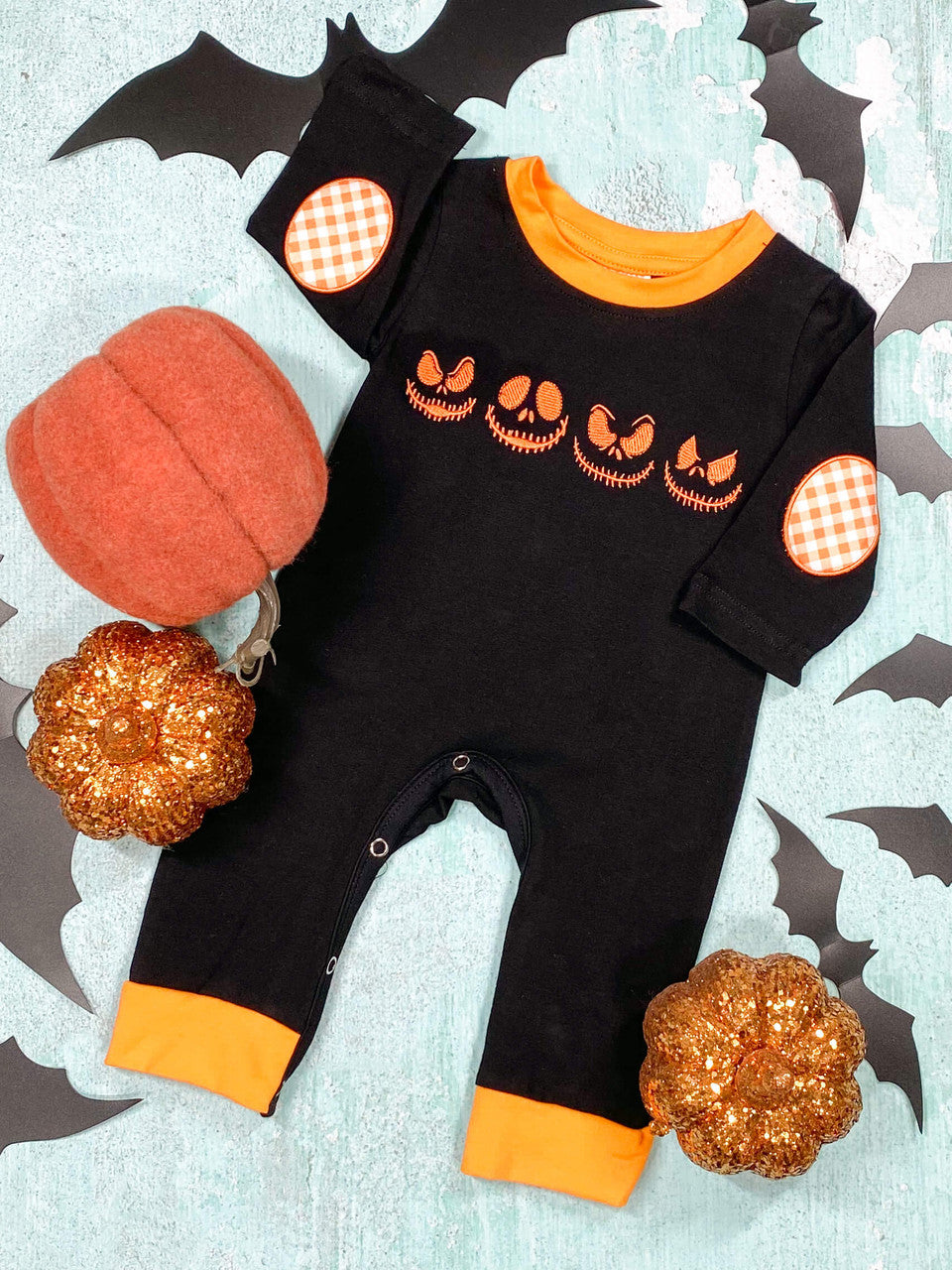 black and orange baby romper with Jack Skellington's eyes and smirk