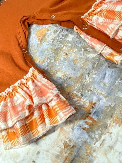 close up photo showing ruffles at end of pant legs and snaps for easy changing