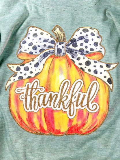 close up of the pumpkin print with a black and white bow tied on stem and thankful written in cursive across the pumpkin
