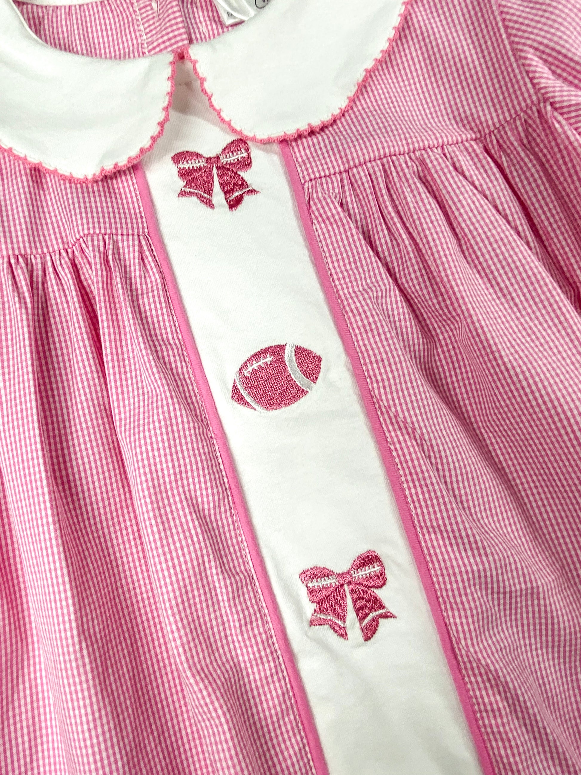 close up of the pink bows and football stitching/embroideries down the center of the dress