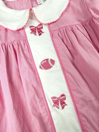 close up of the pink bows and football stitching/embroideries down the center of the dress