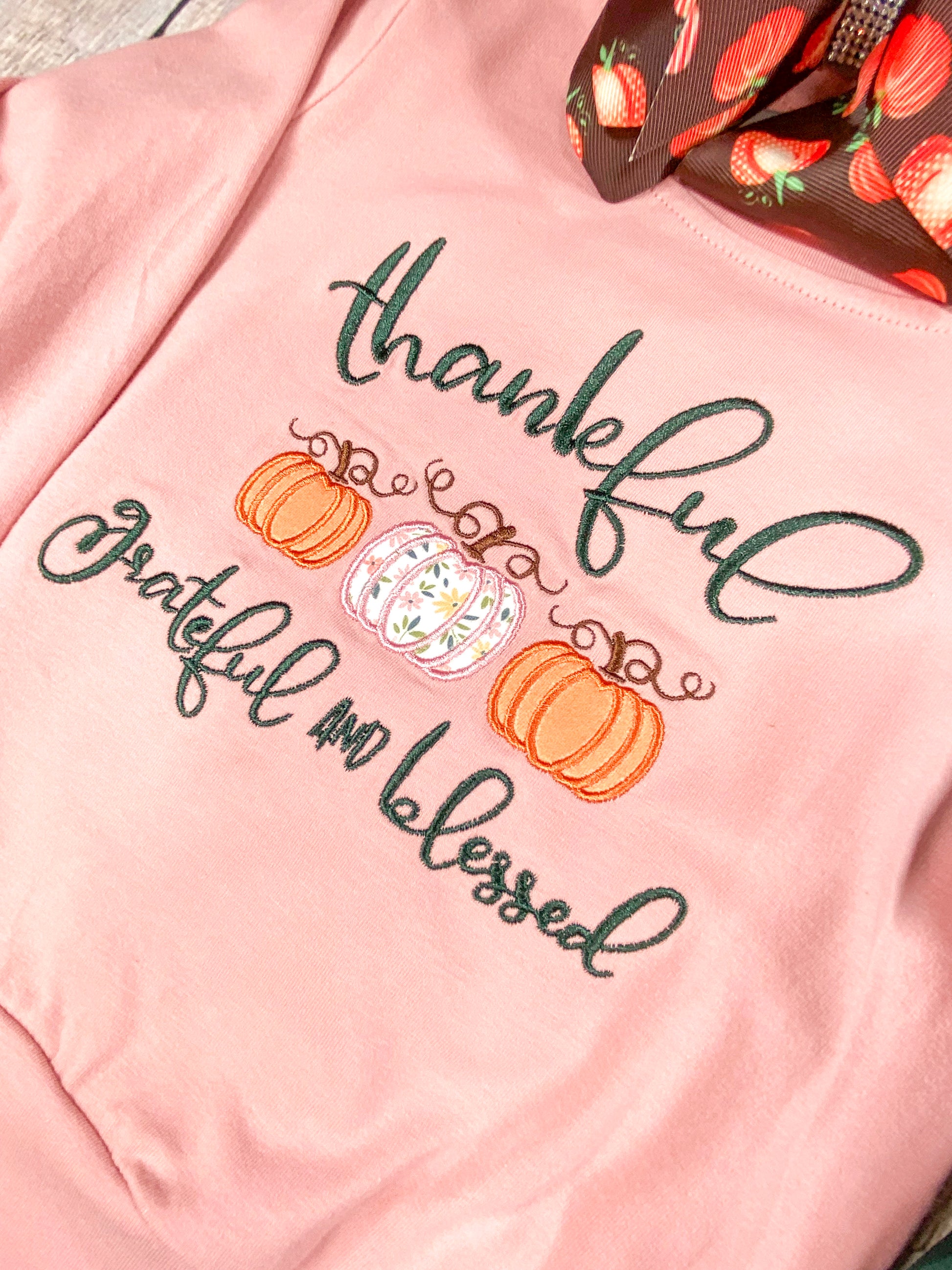 close up of the embroidery saying "thankful grateful and blessed" with 3 pumpkins