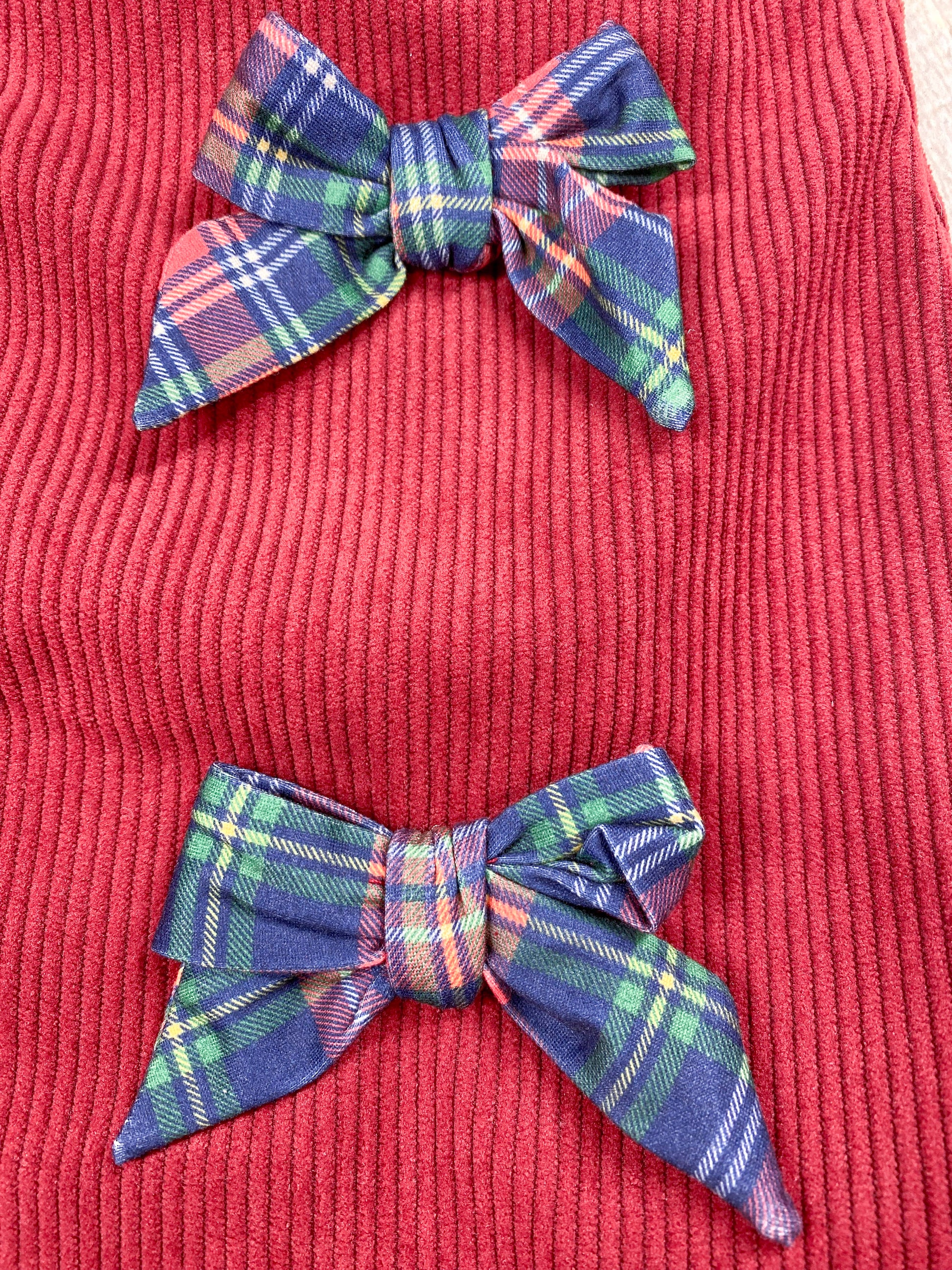 close up of 2 out of the 3 plaid bows on front of dress