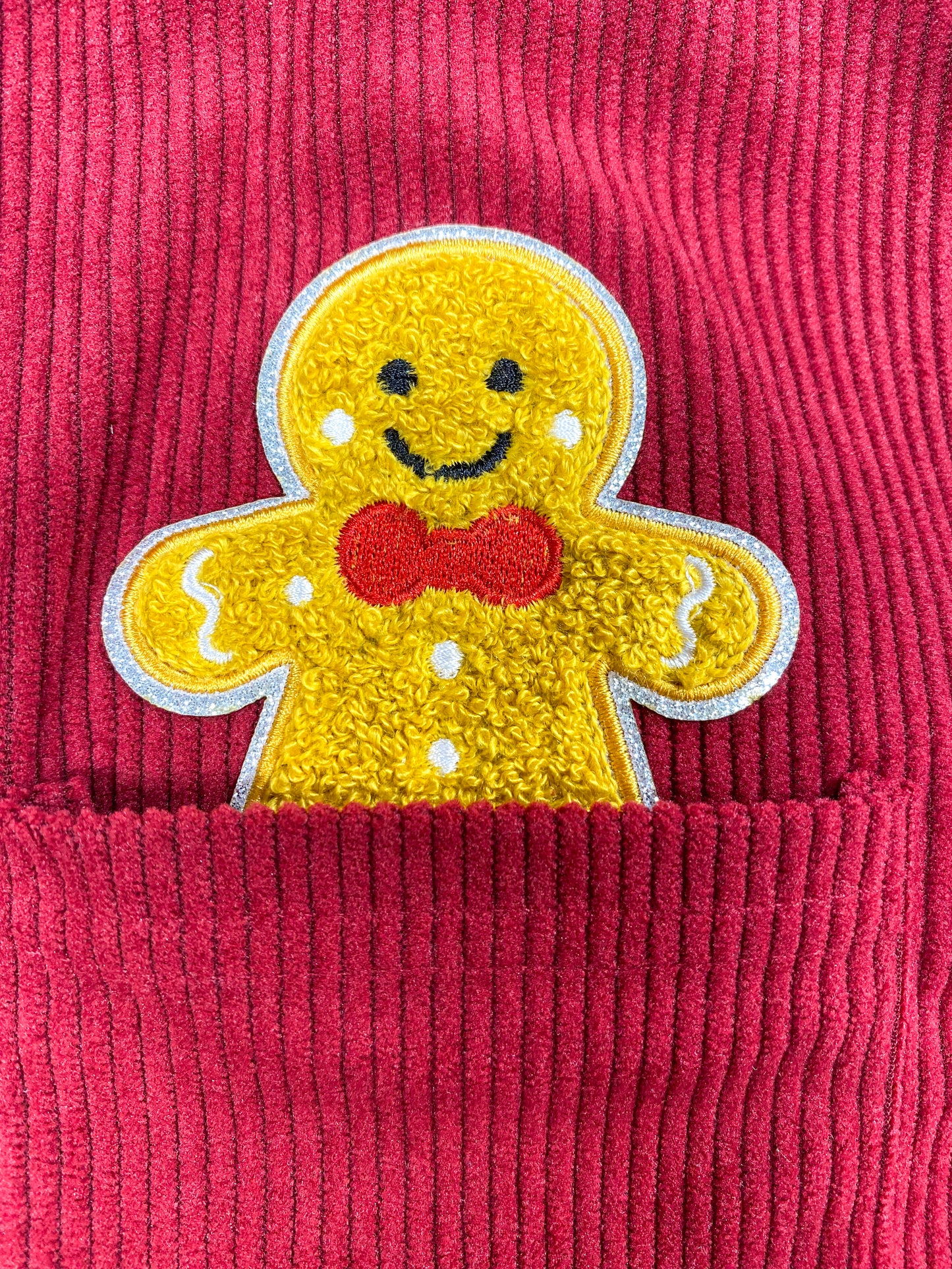 close up of the gingerbread man applique coming out of the front pocket on dress