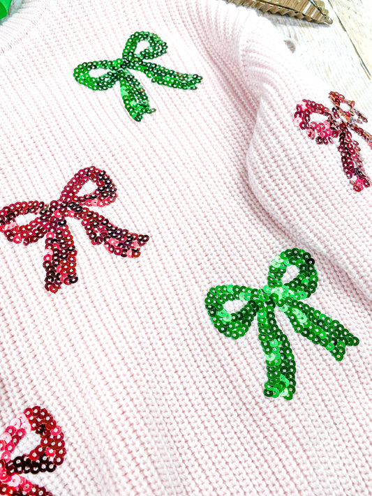 close up of the red and green sequin coquette bows on front of sweater - Alternative view