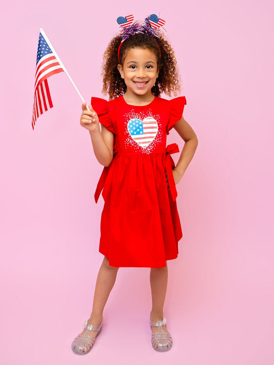 child wearing a red heart flag dress