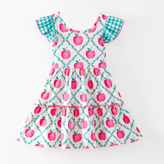 Children's dress with pink apple pattern on a white background