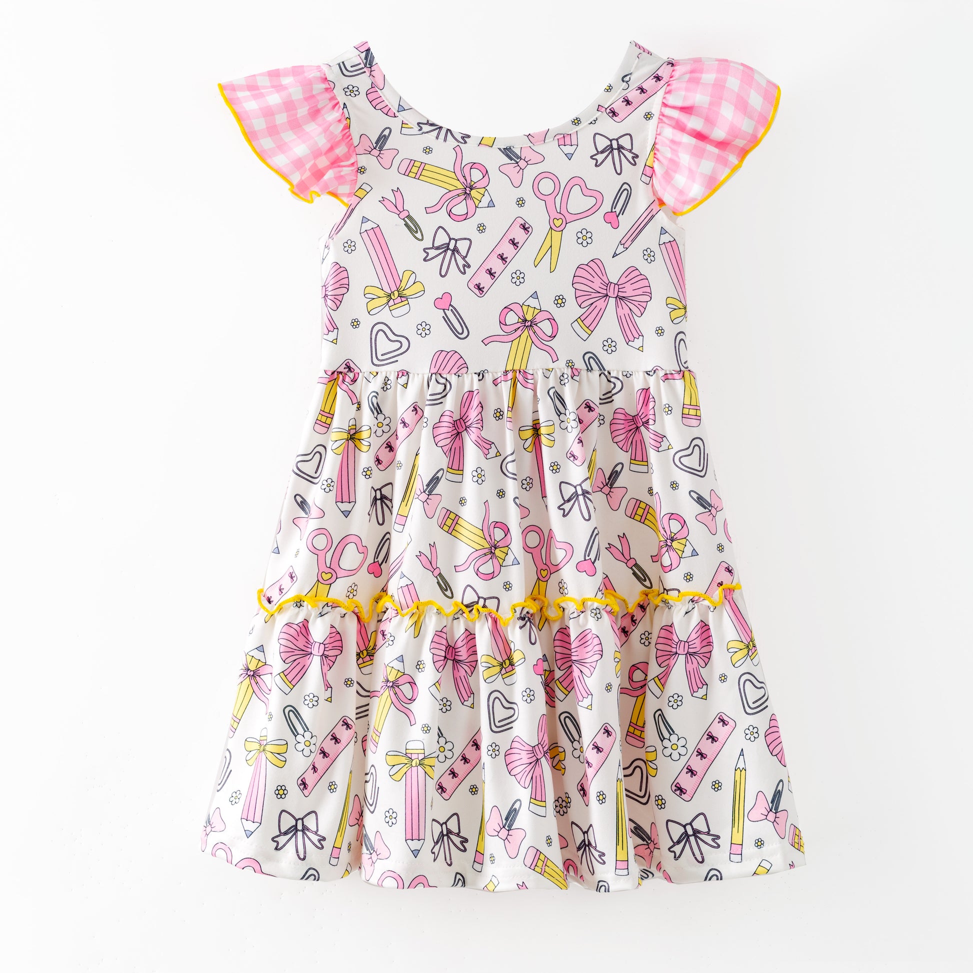 Children's dress with stationery-themed print on a white background