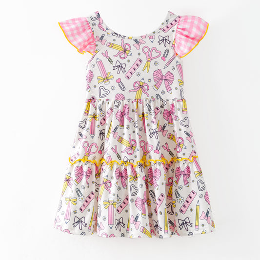 Children's dress with stationery-themed print on a white background