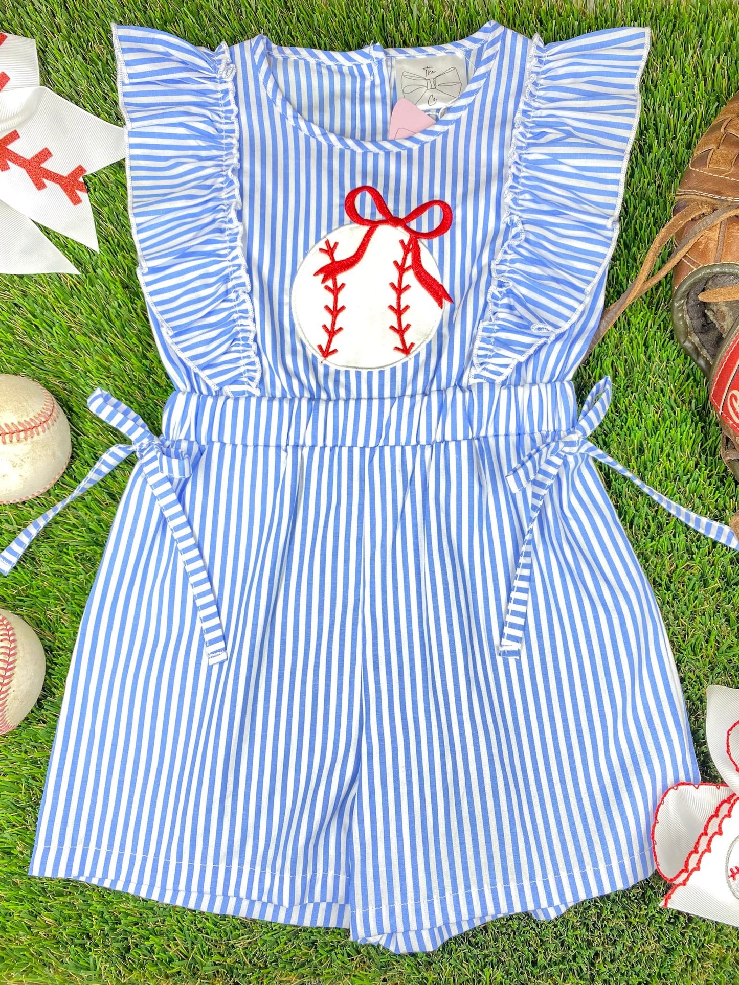 Blue and white striped romper with a  baseball on a grass background