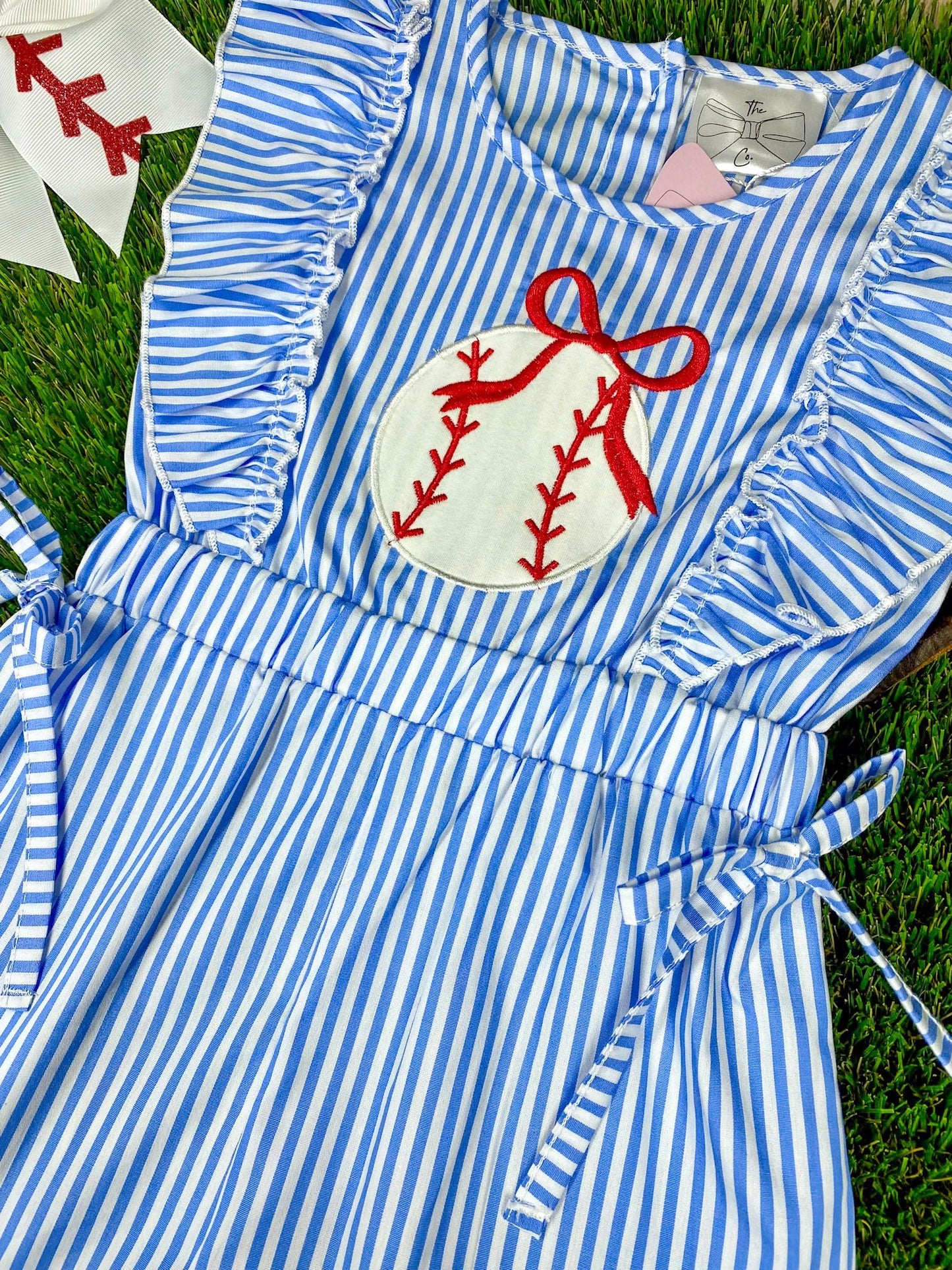 Blue and white striped romper with a  baseball on a grass background
