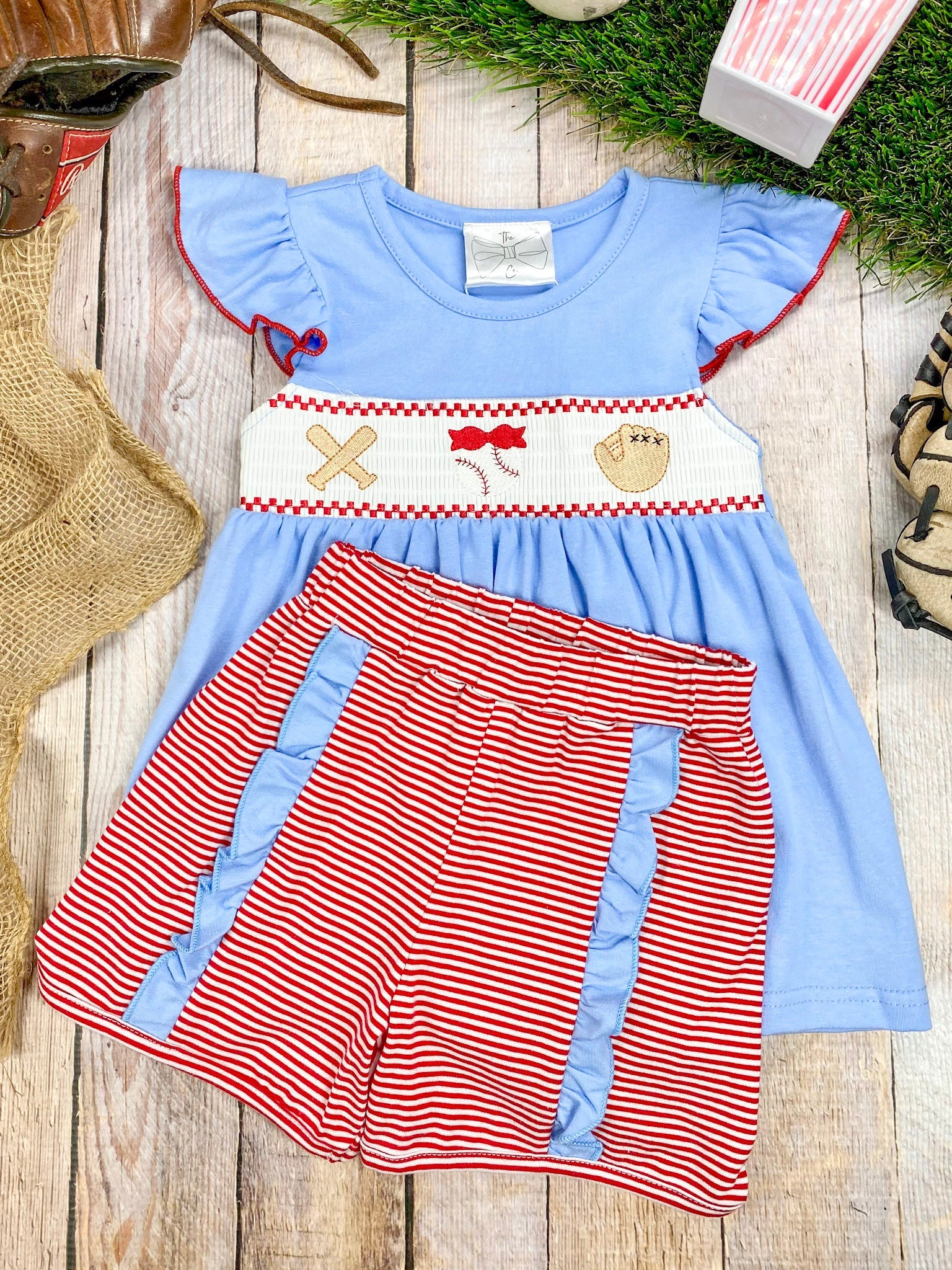 baseball smocked outfit on wood surface
