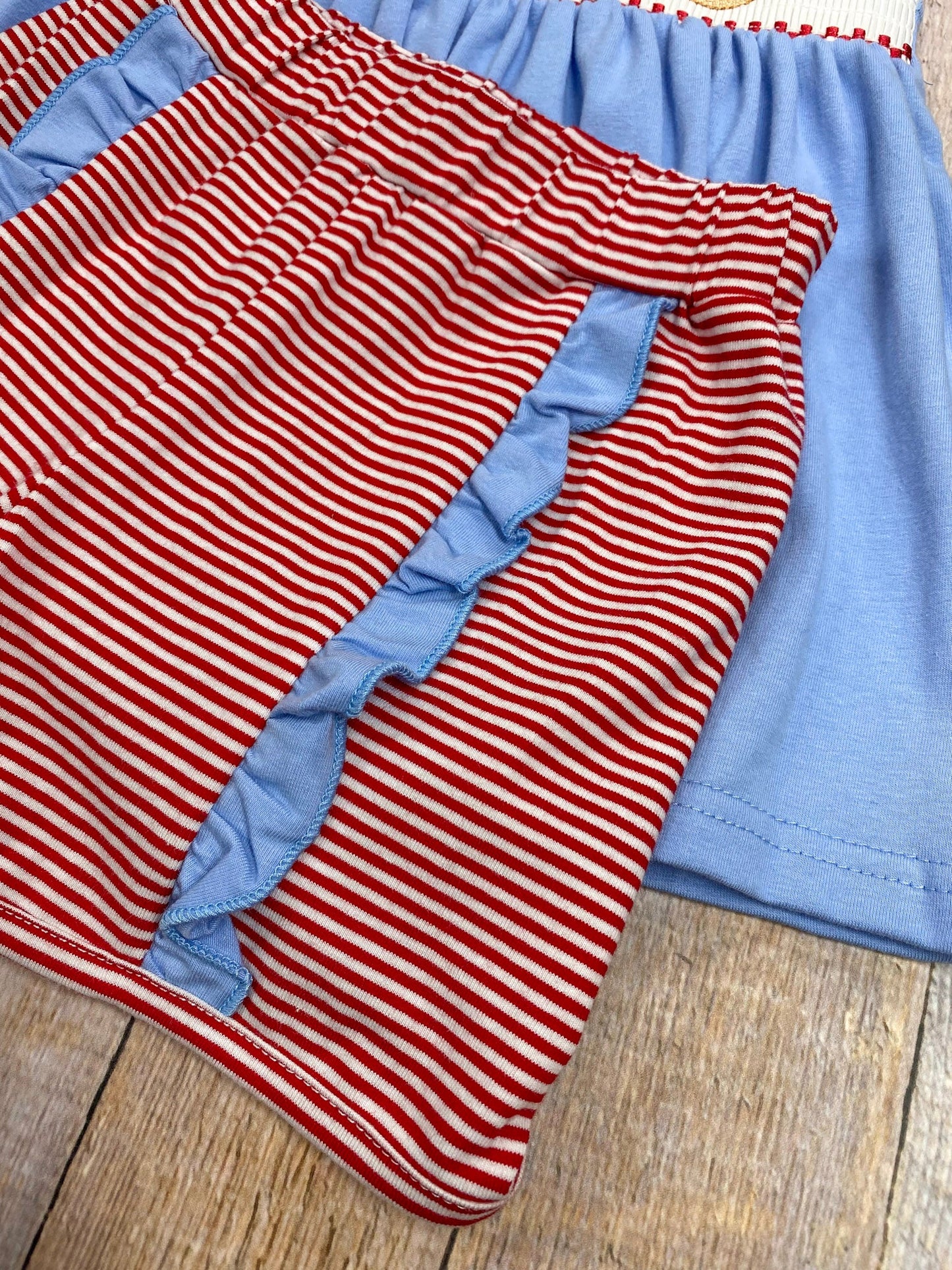 Red and white striped fabric with blue trim on a wooden surface