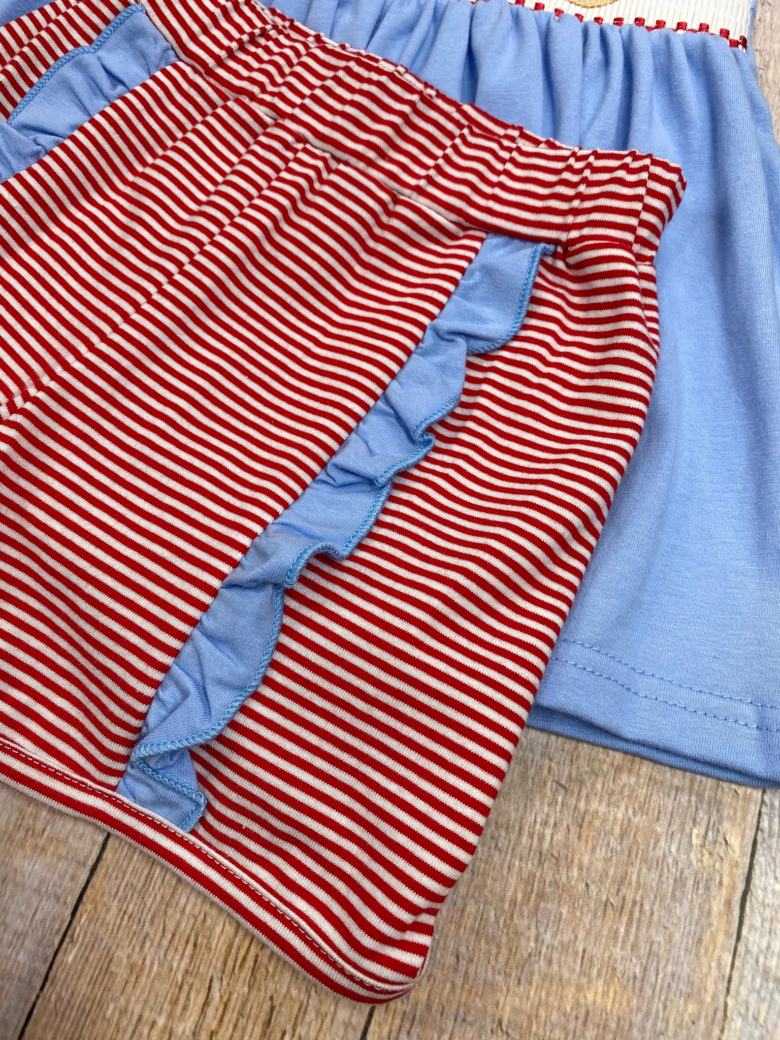 Red and white striped fabric with blue trim on a wooden surface