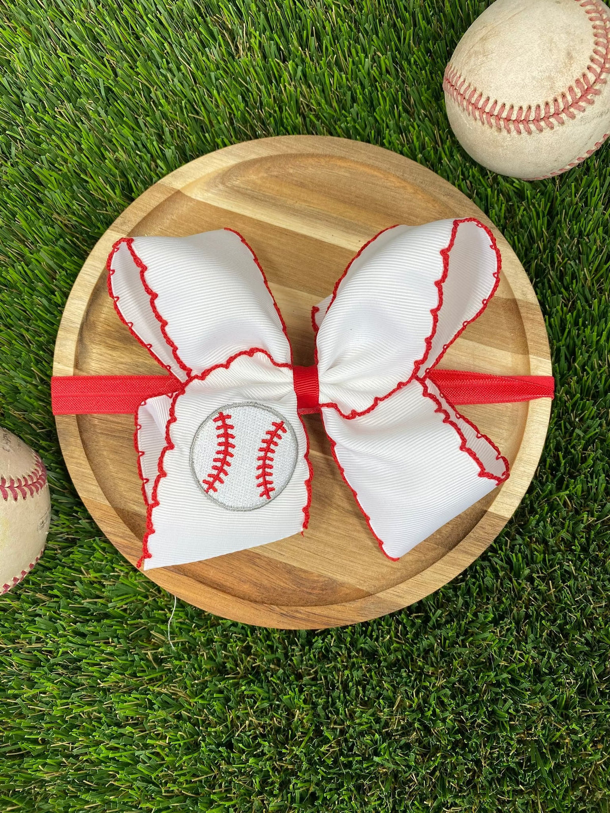 Red and white baseball moonstitch embroidered bow on grass