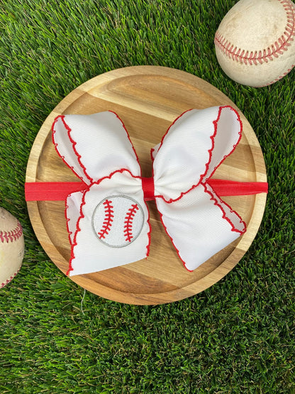 Red and white baseball moonstitch embroidered bow on grass