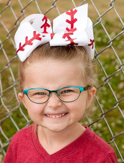 Girl wearing a baseball stitch Texas size hair bow, side angle