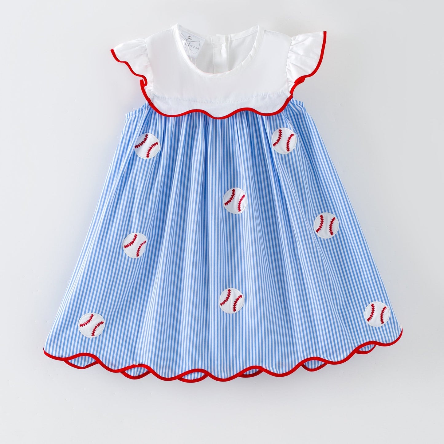 Girl's baseball dress with blue and white striped pattern and red trim on a light gray background