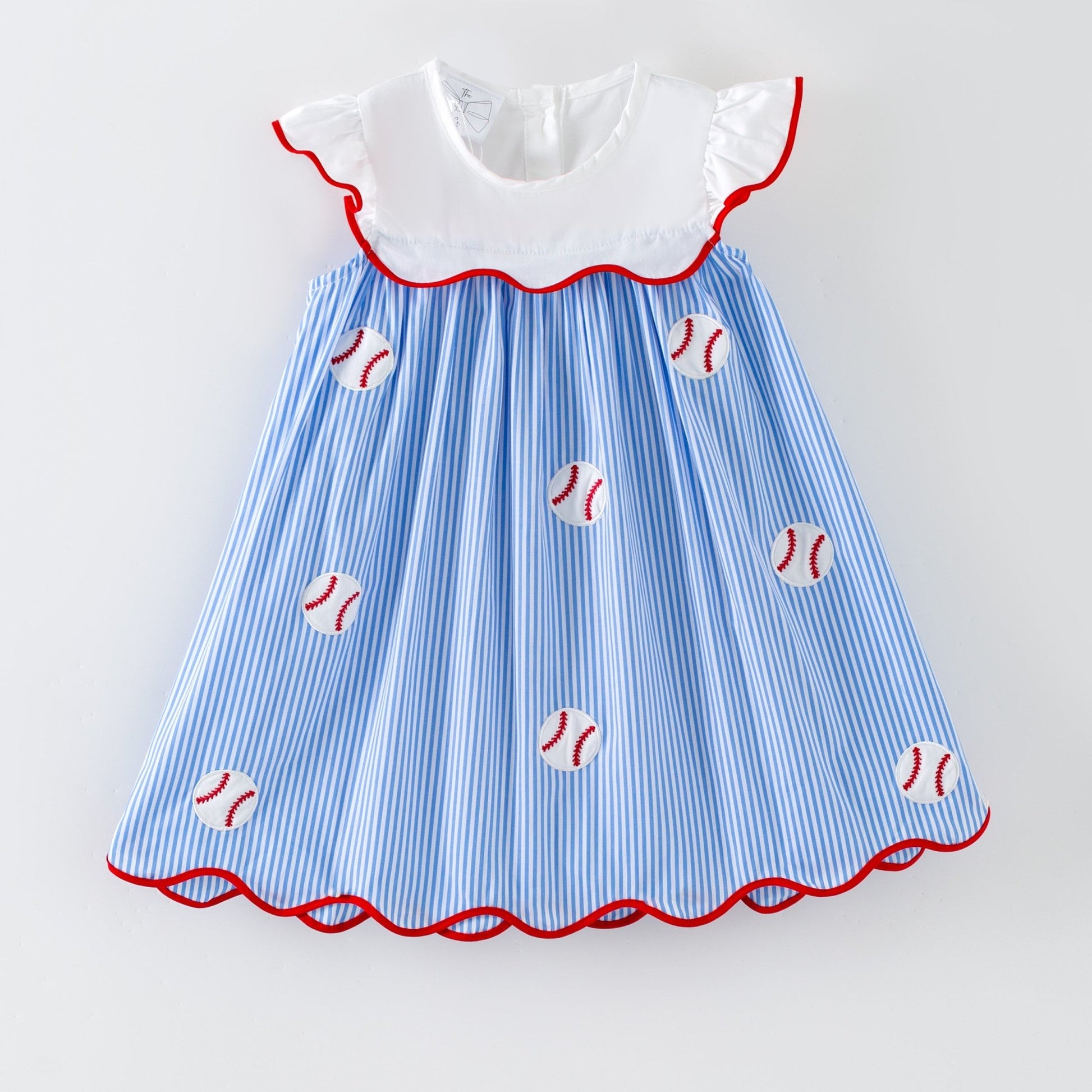 Girl's baseball dress with blue and white striped pattern and red trim on a light gray background