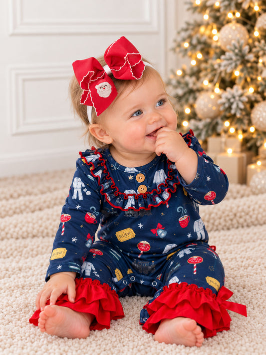model wearing christmas train romper on rug with santa hair bow