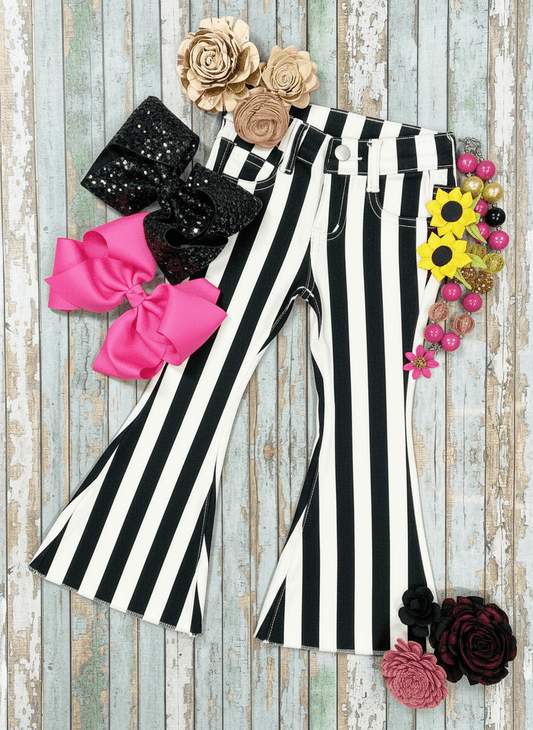 Black and white striped pants with decorative bows and flowers on a wooden background