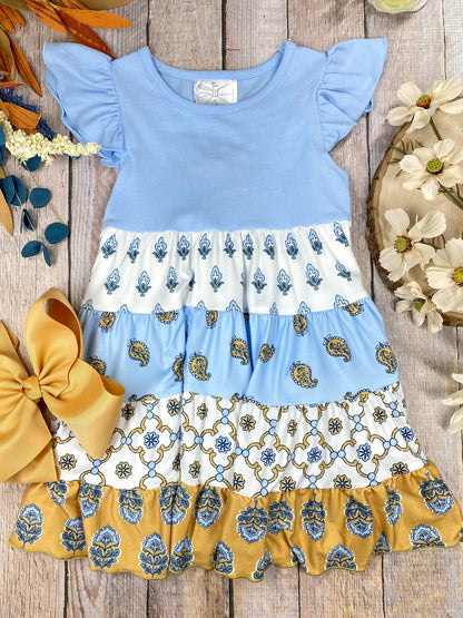 Boutique Boho Children's dress with blue top and floral skirt on a wooden background