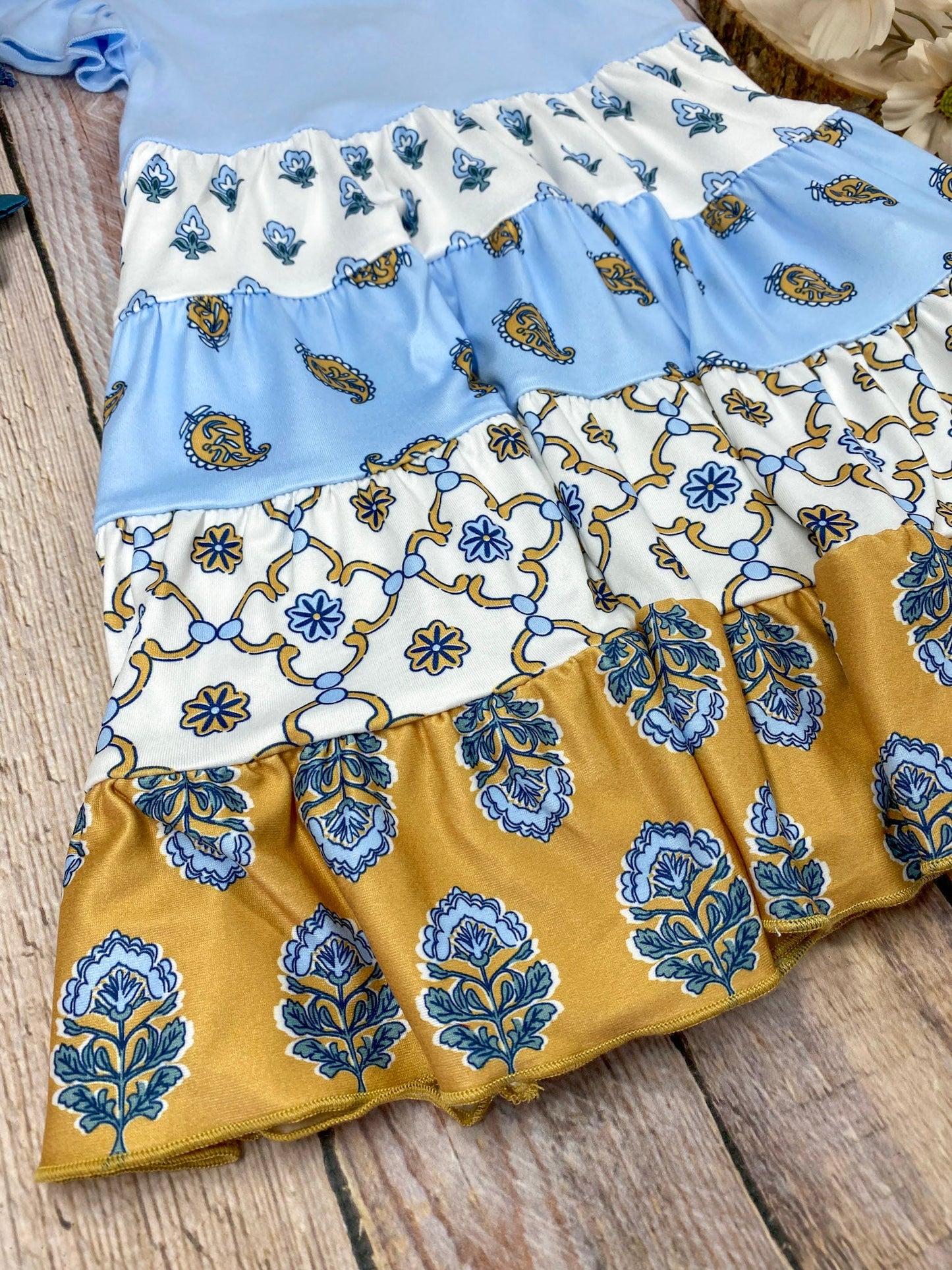 Boutique Boho Children's dress with blue top and floral skirt on a wooden background