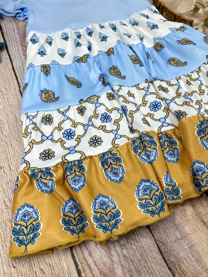 Boutique Boho Children's dress with blue top and floral skirt on a wooden background
