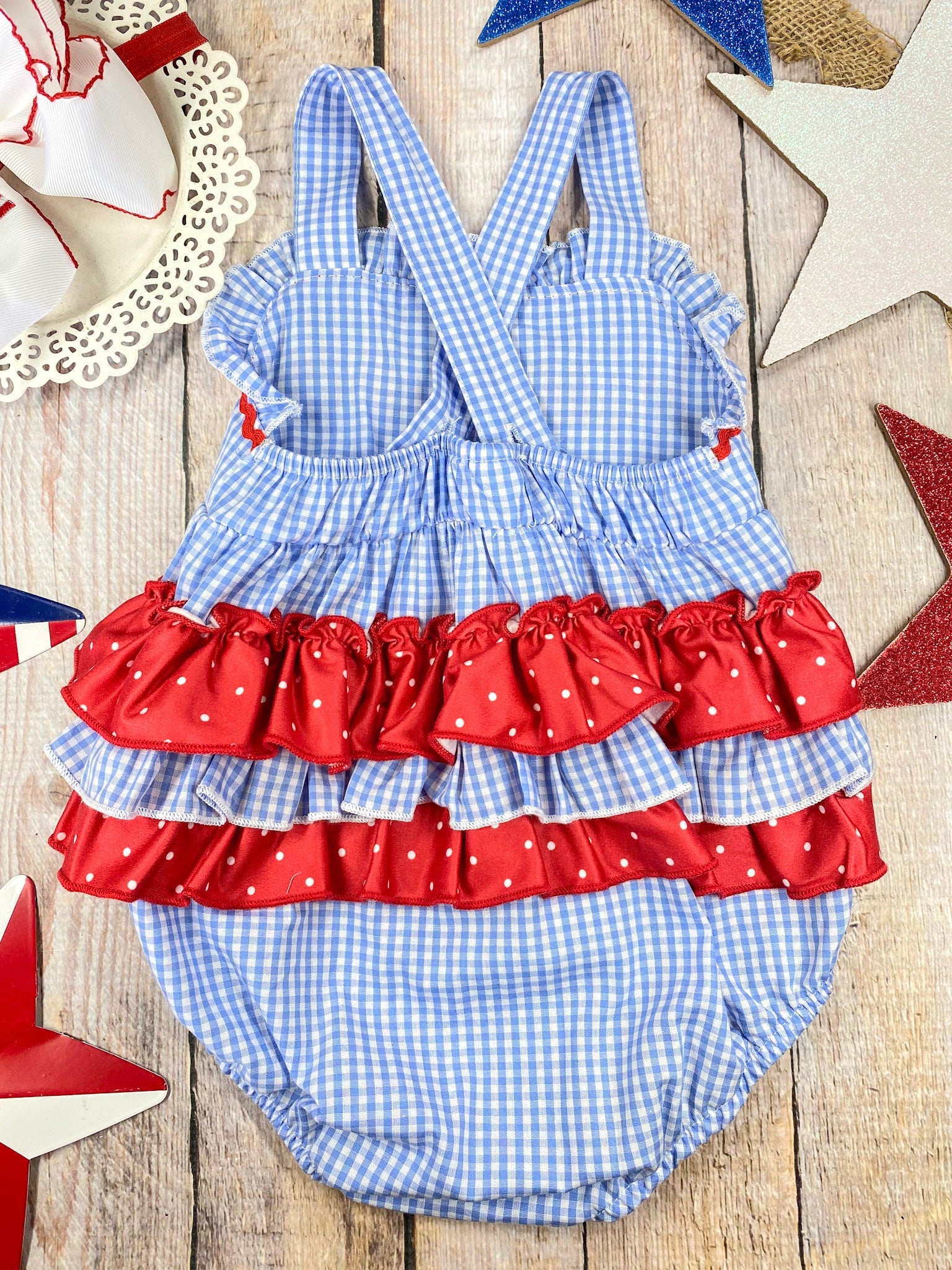 Smocked Flag Gingham Bubble Romper on a wooden background 