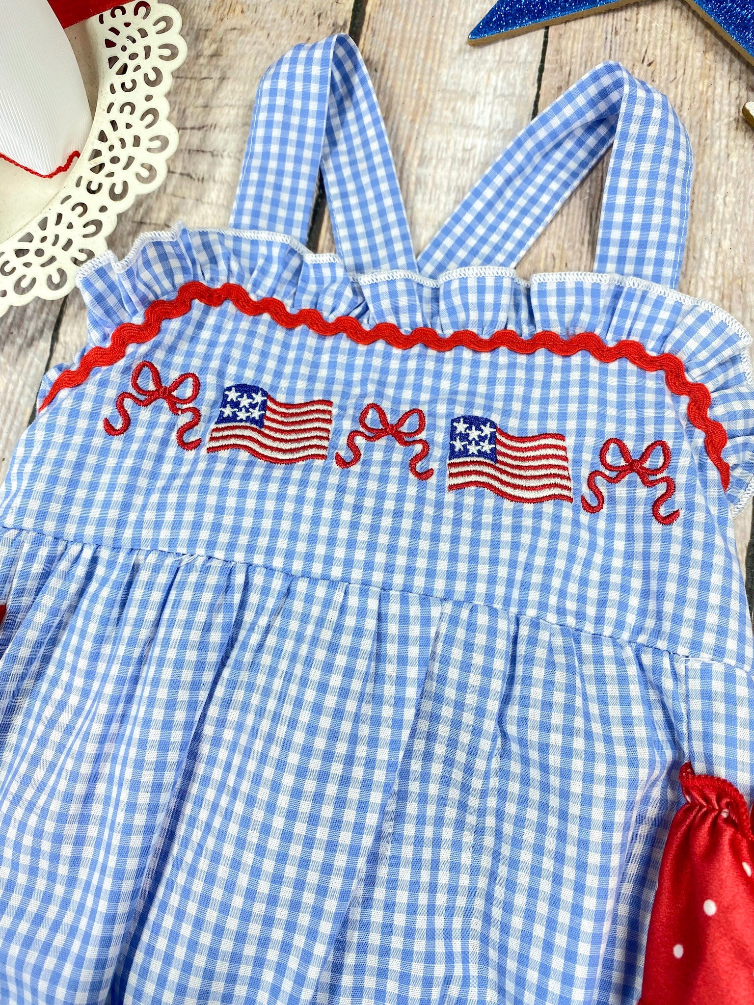 Smocked Flag Gingham Bubble Romper on a wooden background 