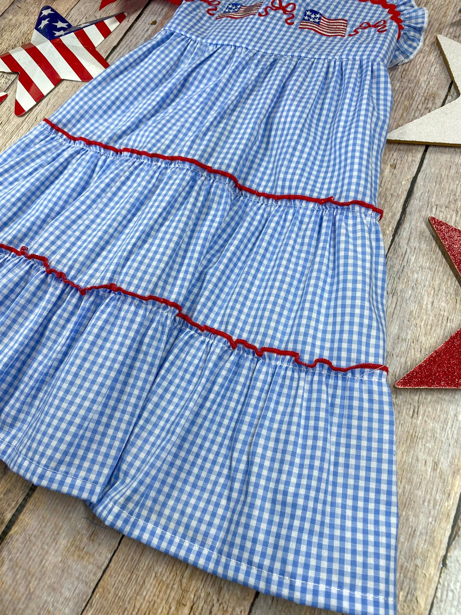  Smocked Flag Gingham Tiered Dress on a wooden background