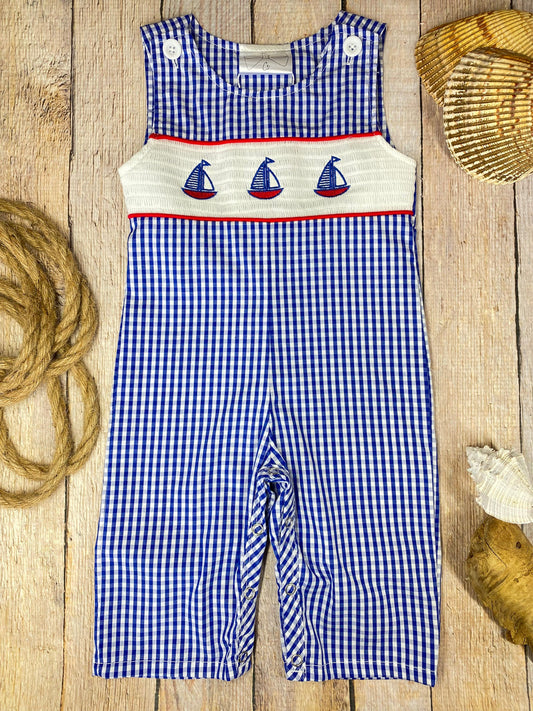 Blue checkered romper with sailboat design on a wooden background