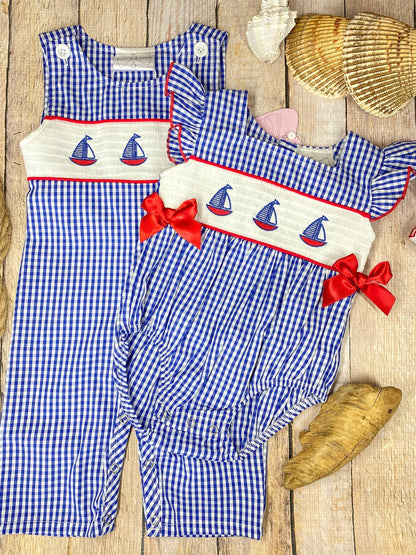 Blue checkered longall and baby romper with sailboat design on a wooden background