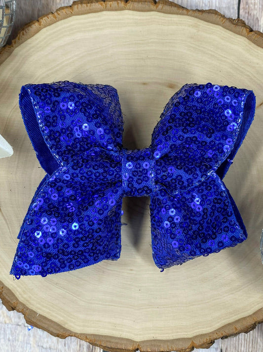 Blue sequin bow on a wooden surface
