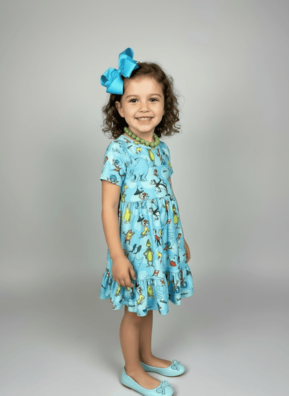 Young girl wearing a blue dress with animal prints against a gray background
