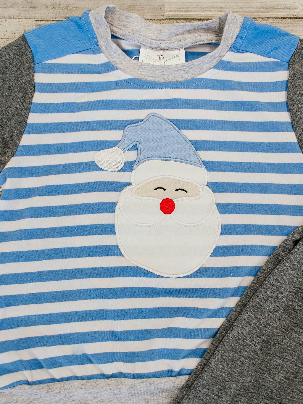 close u of the santa wearing a light blue hat applique with a blue and white striped background