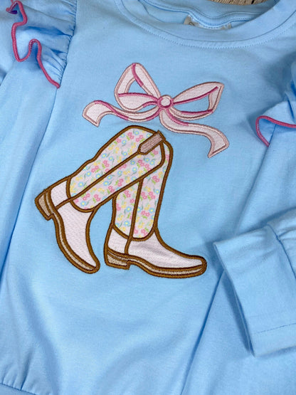 girls cowgirl two-piece with boots appliqué sweatshirt and floral bell bottoms on a wooden background