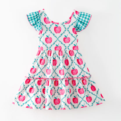 Children's dress with pink apple pattern on a white background