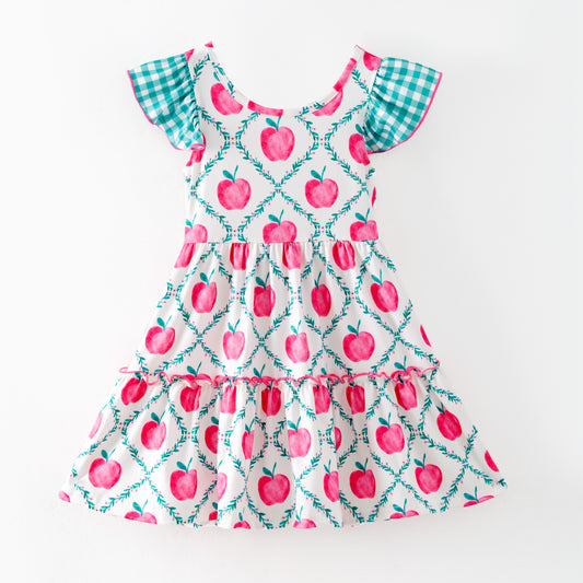 Children's dress with pink apple pattern on a white background