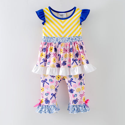 Children's outfit with yellow and purple striped top and floral pants on a gray background