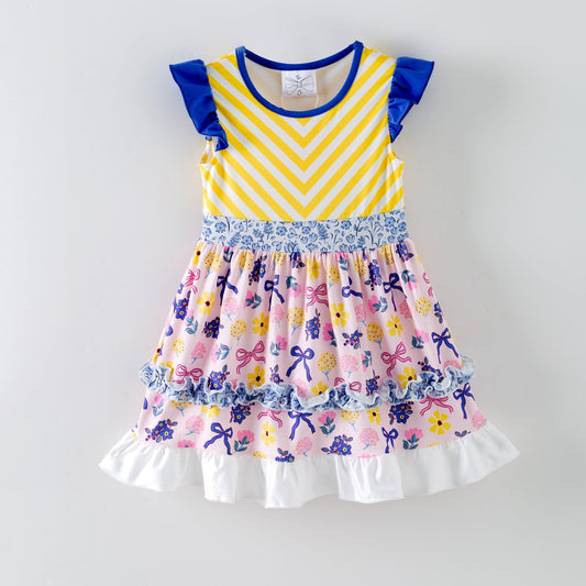 Colorful children's dress with yellow and purple striped top and floral skirt on a white background