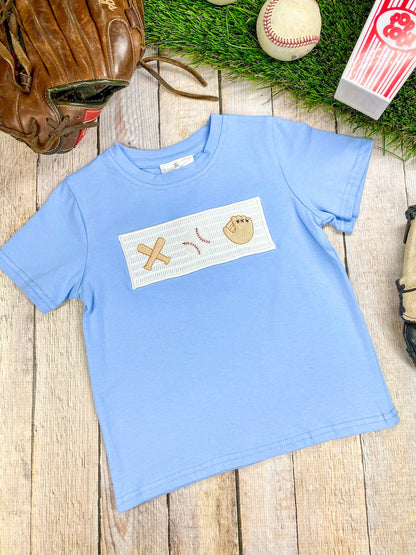 Blue t-shirt with a graphic design on a wooden surface with sports equipment.