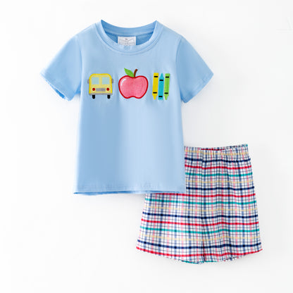 Children's outfit with light blue shirt and plaid shorts on a white background