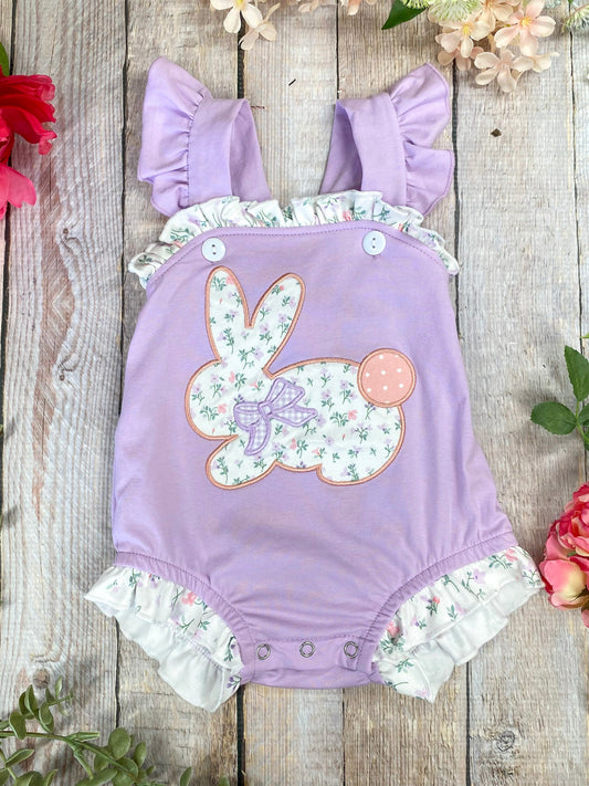 purple baby romper with floral bunny design on a wooden background