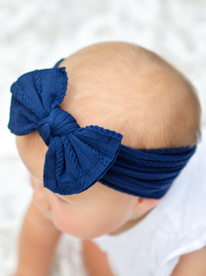 Girl wearing a navy cable knit bow headband