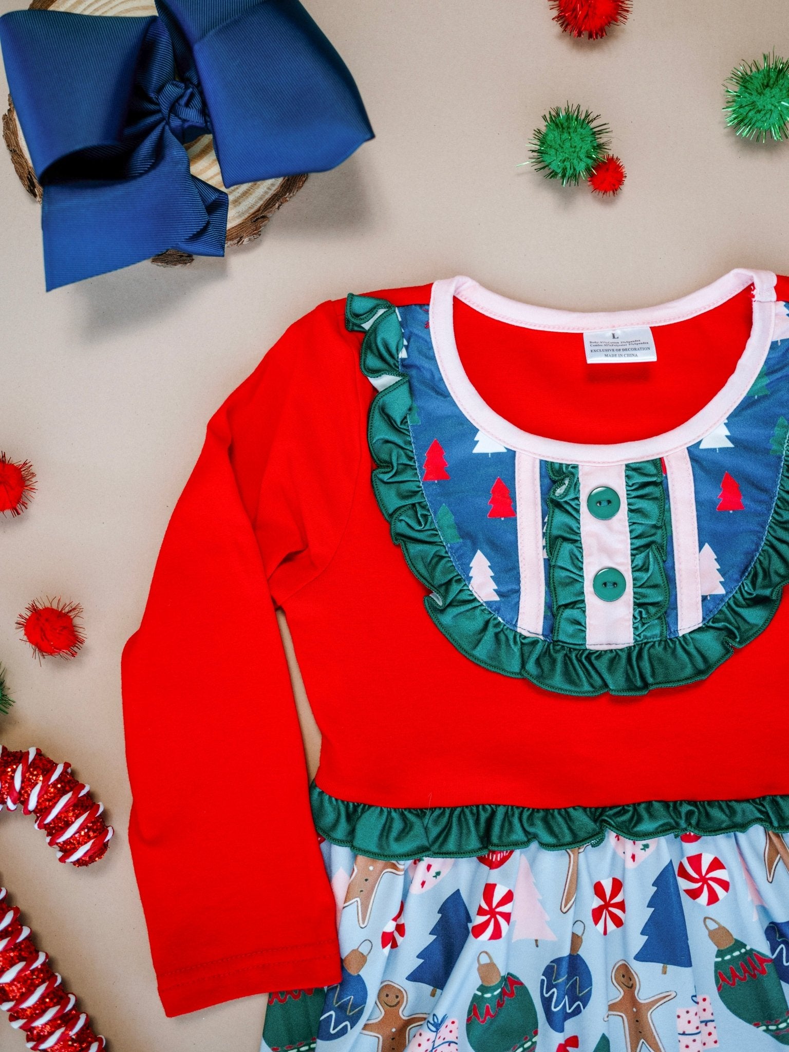 Red Christmas-themed dress with blue ruffled collar and festive patterns on a beige background.